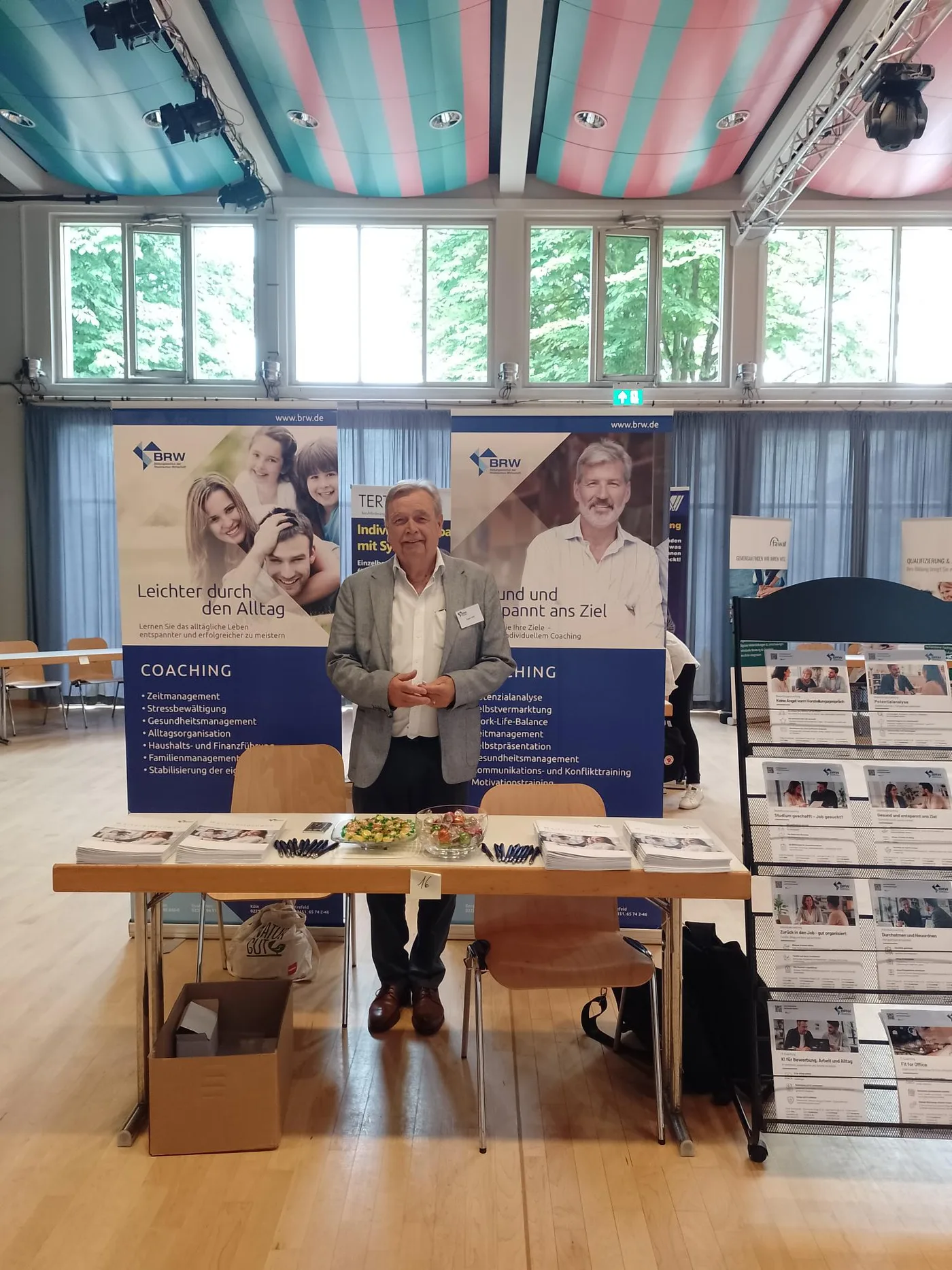 BRW-Mitarbeiter am Messestand mit Coaching-Rollups auf der Gutschein-Messe