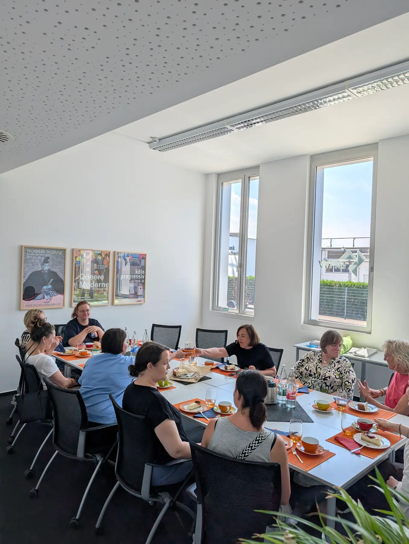 Kaffeetafel mit Teilnehmerinnen und BRW-Team in den Räumen des BRW, im Hintergrund das BRW-Logo am Fenster