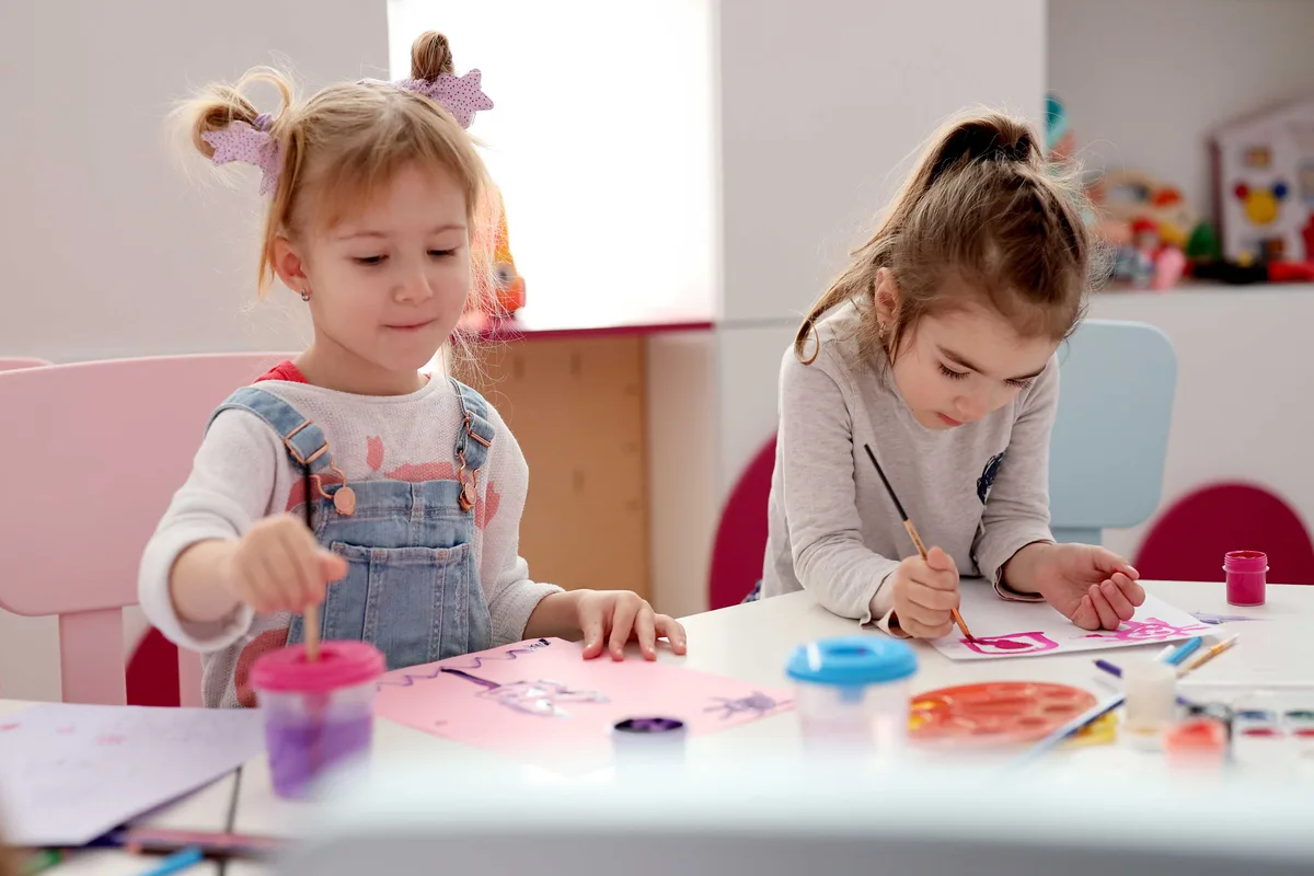 Kindergärtnerin spielt mit Kindern im Stuhlkreis