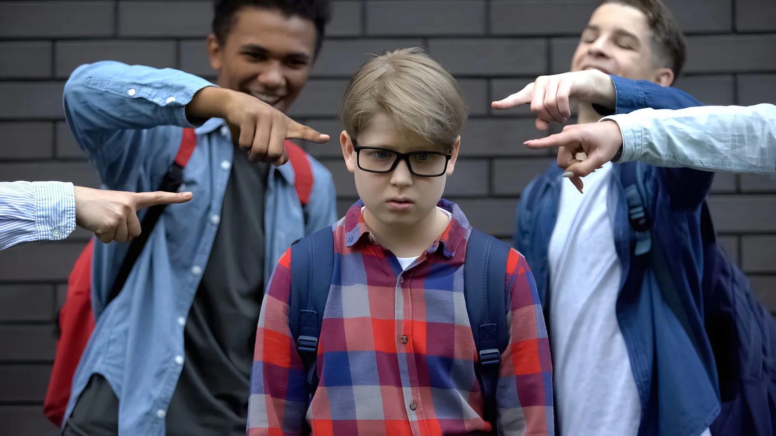 Ein Junge wird von Mitschülern mit dem Finger gezeigt und ausgegrenzt